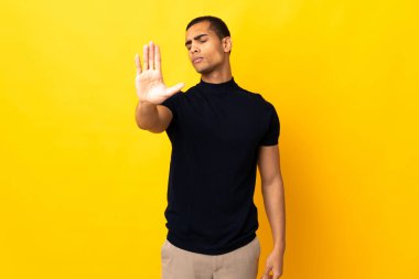 Afrikalı Amerikalı bir adam izole edilmiş arka planda durup jest yapıyor ve hayal kırıklığına uğruyor.