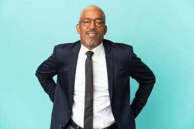 İşletme son sınıf öğrencisi mavi arka planda izole edilmiş, gayret gösterdiği için sırt ağrısı çekiyor.