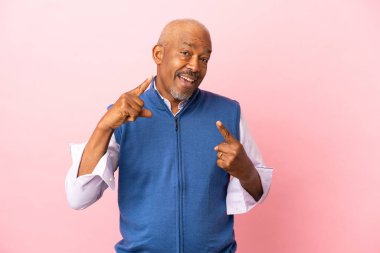 Kübalı son sınıf öğrencisi pembe arka planda izole edilmiş.