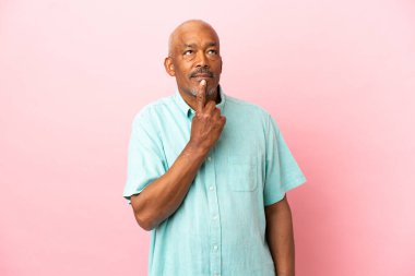 Kübalı son sınıf öğrencisi pembe arka planda izole edildi.