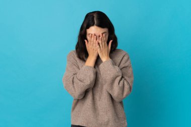 Genç Ukraynalı kız yorgun ve hasta bir ifadeyle mavi arka planda izole edilmiş.