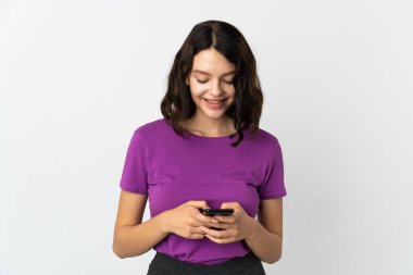 Genç Ukraynalı kız beyaz arka planda izole edilmiş bir şekilde cep telefonuyla mesaj ya da e-posta gönderiyor