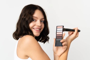 Genç Ukraynalı kız beyaz arka planda makyaj paleti ile izole edilmiş.