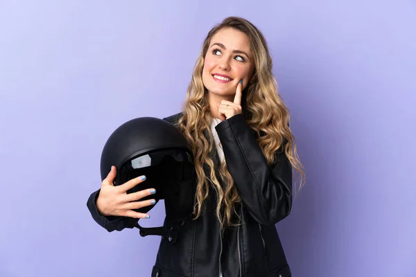 Молодая Бразилька Держащая Мотоциклетный Шлем Изолирована Фиолетовом Фоне Думая Идее — стоковое фото