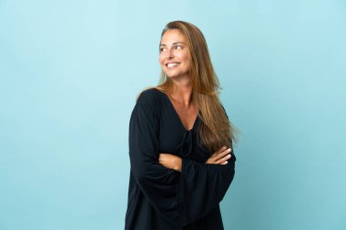 Mavi arka planda izole edilmiş orta yaşlı Brezilyalı kadın.