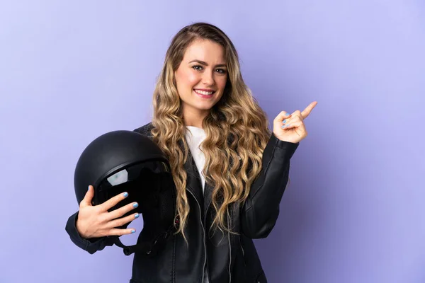 Молодая Бразилька Держащая Мотоциклетный Шлем Изолирована Фиолетовом Фоне Указывая Пальцем — стоковое фото