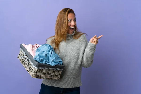 Frau Mittleren Alters Hält Einen Wäschekorb Isoliert Auf Lila Hintergrund — Stockfoto