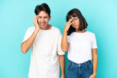 Genç melez çift mavi arka planda izole edilmiş mutsuz ve hayal kırıklığına uğramış bir şekilde.