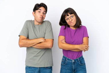 İzole edilmiş beyaz arka planda genç bir çift omuzlarını kaldırırken şüphe jesti yapıyor.