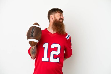 Beyaz arka planda ragbi oynayan, beyaz tenli, beyaz tenli, beyaz bir adam, gayret gösterdiği için sırt ağrısından muzdarip.