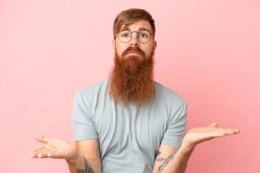 Pembe arka planda izole edilmiş genç, beyaz bir adam. Şüpheleri var.