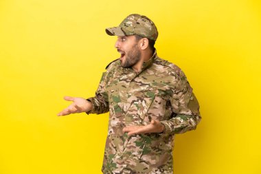 Asker, sarı arka planda izole edilmiş, şaşırmış bir yüz ifadesi var.