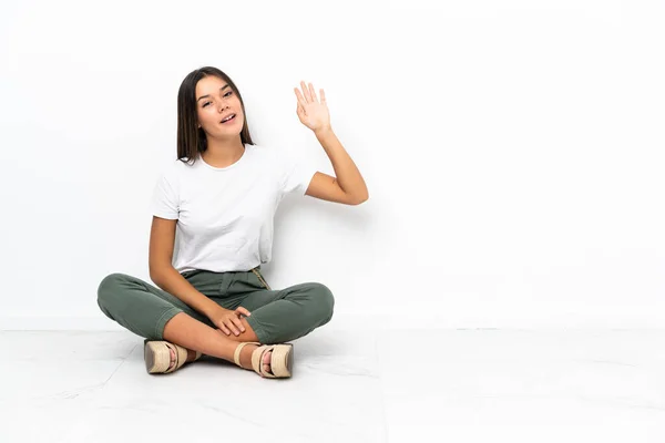 Adolescente Chica Sentada Suelo Saludando Con Mano Con Expresión Feliz — Foto de Stock