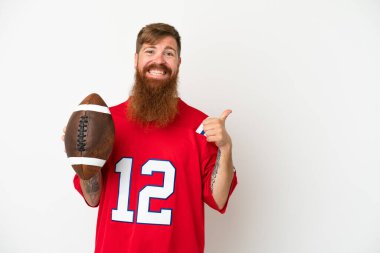 Beyaz arka planda ragbi oynayan Kafkasyalı genç adam bir ürünü sunmak için yan tarafı işaret ediyor.