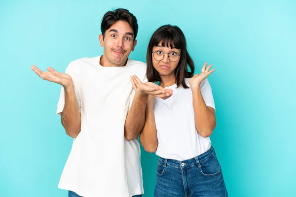 Young Mixed Race Couple Isolated Blue Background Having Doubts While — Stock Photo, Image