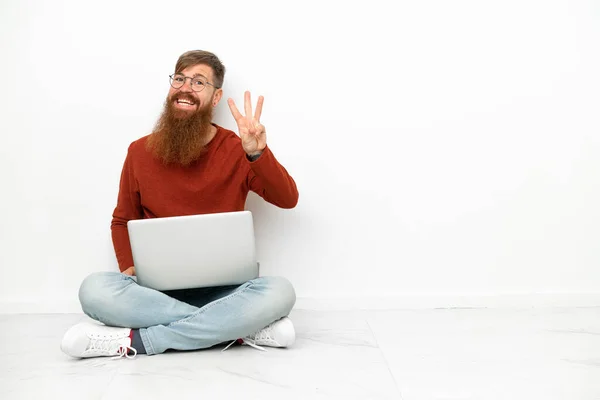 年轻红头发的高加索人 拿着笔记本电脑 背景是白色的 快乐极了 手指头数三下 — 图库照片