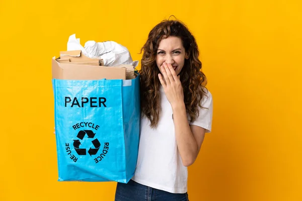 Młoda Kobieta Trzyma Worek Papierem Recyklingu Odizolowany Żółtym Tle Szczęśliwy — Zdjęcie stockowe