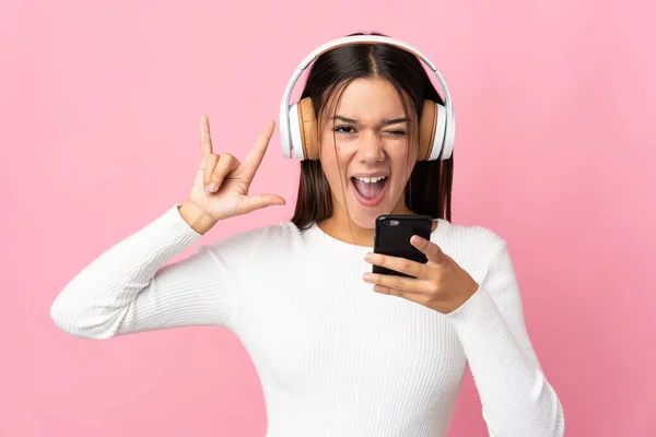 Teenager Κορίτσι Απομονωμένο Μπλε Φόντο Ακούγοντας Μουσική Ένα Κινητό Κάνοντας — Φωτογραφία Αρχείου
