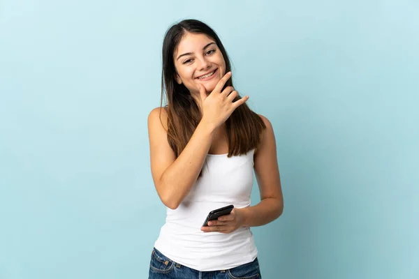Молода Біла Жінка Допомогою Мобільного Телефону Ізольована Синьому Фоні Щаслива — стокове фото