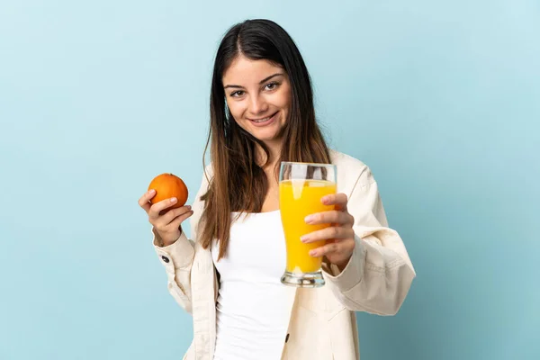 Ung Kaukasisk Kvinna Isolerad Blå Bakgrund Håller Apelsin Och Apelsinjuice — Stockfoto
