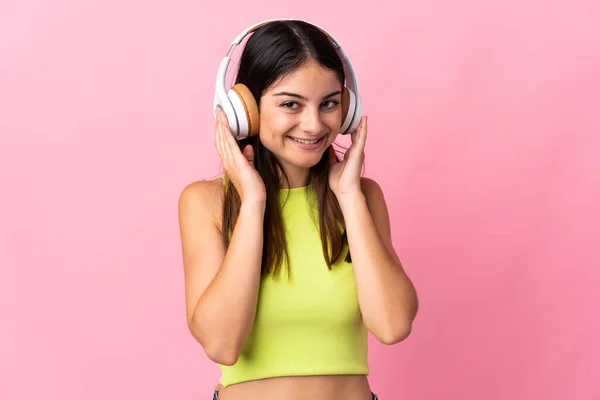 Молодая Белая Женщина Изолированная Розовом Фоне Слушает Музыку — стоковое фото