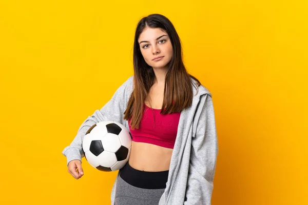 年轻的高加索女人在黄色背景下与足球隔离 — 图库照片
