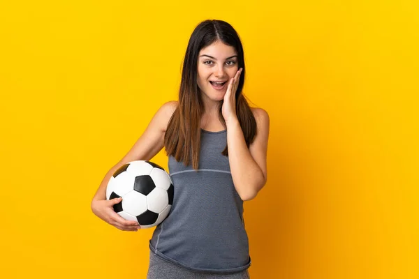 若いサッカー選手の女性は驚きとショックを受けた顔の表情で黄色の背景に隔離 — ストック写真