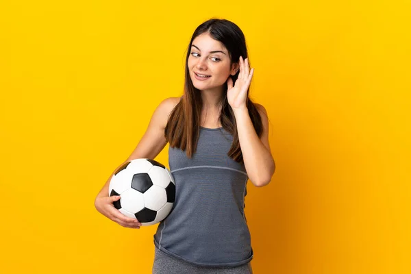Giovane Giocatore Calcio Donna Isolato Sfondo Giallo Ascoltando Qualcosa Mettendo — Foto Stock