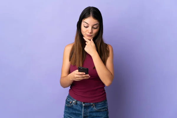 Mujer Joven Caucásica Aislada Sobre Fondo Púrpura Pensando Enviando Mensaje —  Fotos de Stock