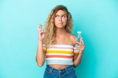 Mavi arka planda su şişesi olan genç sarışın kadın, şans diliyor ve en iyisini diliyor