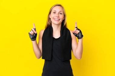 Beyaz arka planda izole edilmiş genç İngiliz kadın harika bir fikre işaret ediyor.