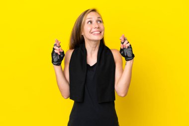 Genç İngiliz spor kadını beyaz arka planda izole edilmiş ve şans diliyor.