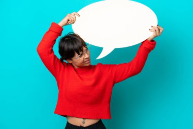 Mavi arka planda izole edilmiş genç bir kadın elinde boş bir konuşma balonu ve üzgün bir ifadeyle