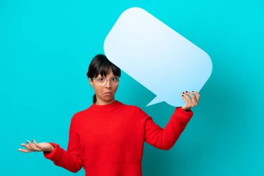 Mavi arka planda izole edilmiş genç bir kadın boş bir konuşma balonu tutuyor ve kuşkuları var.