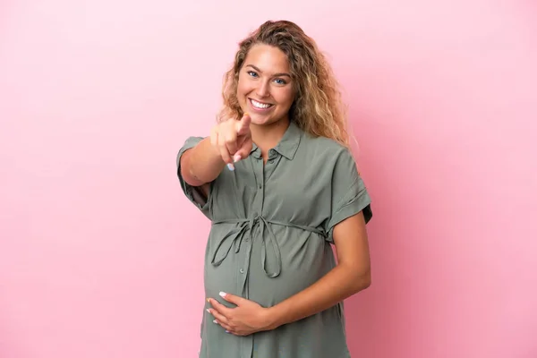 Chica Con Pelo Rizado Aislado Sobre Fondo Rosa Embarazada Apuntando —  Fotos de Stock