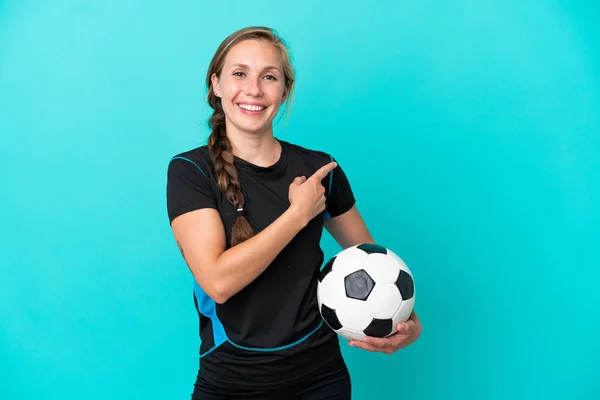 Mladá Anglická Žena Izolované Modrém Pozadí Fotbalovým Míčem Ukazuje Boční — Stock fotografie