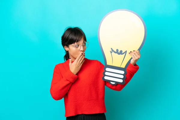 Young Woman Isolated Blue Background Holding Bulb Icon Surprised Expression — Stock Photo, Image