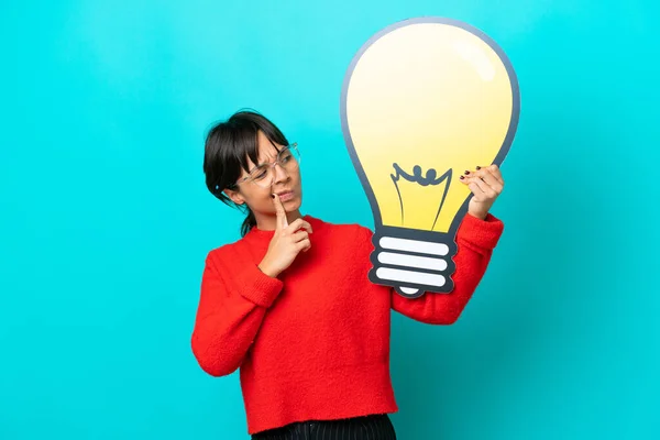 Young Woman Isolated Blue Background Holding Bulb Icon Having Doubts — Stock Photo, Image