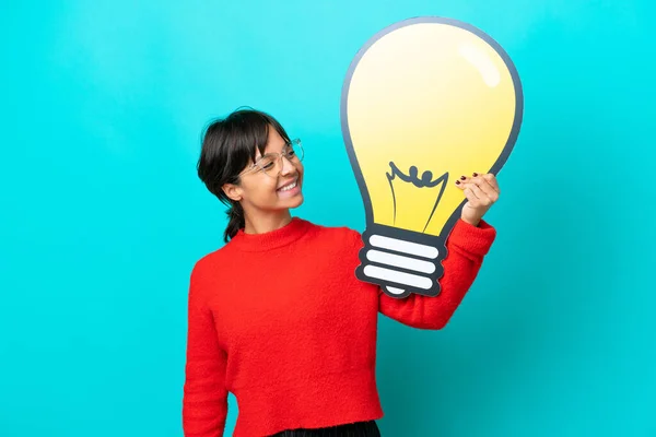 Young Woman Isolated Blue Background Holding Bulb Icon Happy Expression — Stock Photo, Image