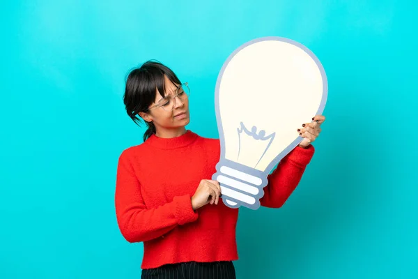 Young Woman Isolated Blue Background Holding Bulb Icon Having Doubts — Stock Photo, Image