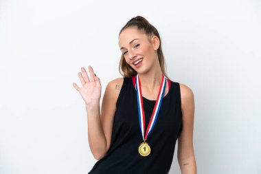 Beyaz arka planda soyutlanmış beyaz madalyalı beyaz bir kadın mutlu bir ifadeyle selamlıyor.