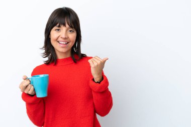 Beyaz arka planda izole edilmiş bir fincan kahve taşıyan beyaz bir kadın bir ürünü sunmak için kenarı işaret ediyor.