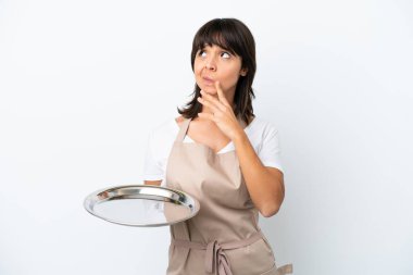 Tepsisi beyaz arka planda izole edilmiş genç garson yukarı bakarken şüpheleri var.