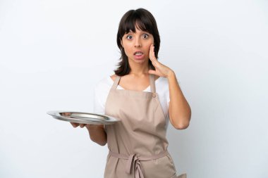 Tepsisi beyaz arka planda, şaşırmış ve şok olmuş bir yüz ifadesi olan genç bir garson.