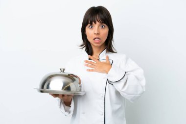 Tepsisi beyaz arka planda olan genç aşçı sağa bakarken şaşırdı ve şok oldu.