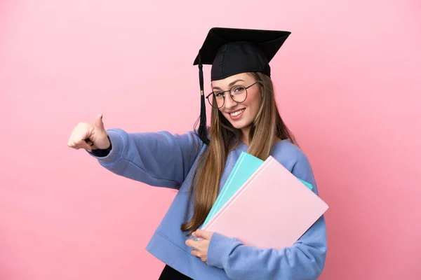 Młoda Studentka Ubrana Kapelusz Absolwentki Odizolowana Różowym Tle Podnosząca Kciuk — Zdjęcie stockowe