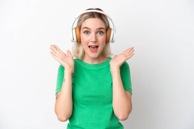 Beyaz arka planda izole genç beyaz kadın şaşırdı ve müzik dinliyor