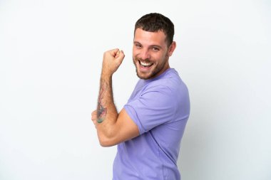 Genç Brezilyalı izole edilmiş beyaz arka planda zaferi kutluyor.