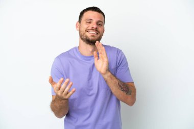 Beyaz arka planda izole edilmiş genç Brezilyalı bir adam bir konferanstan sonra alkışlıyor.