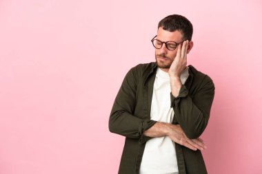 Pembe arka planda başağrısı olan Brezilyalı genç bir adam.
